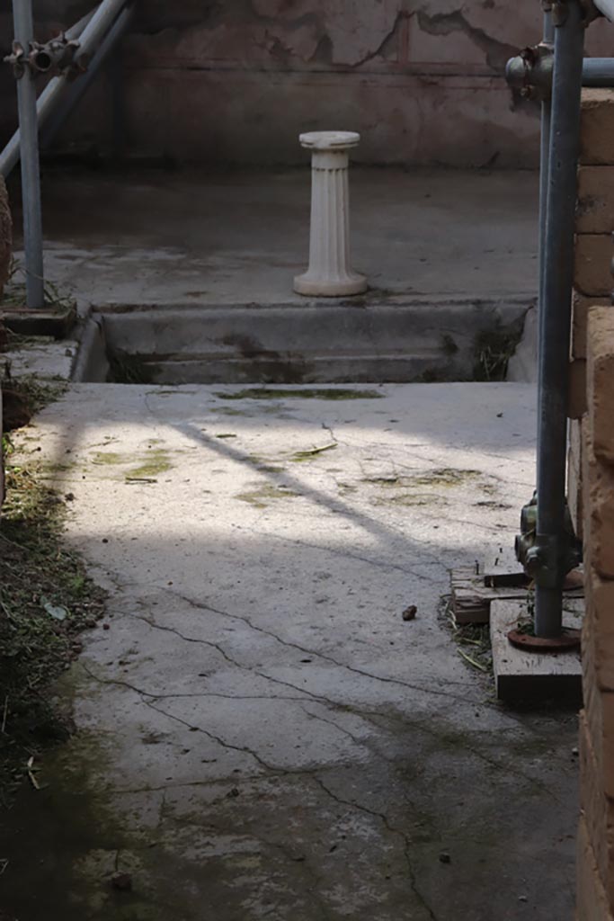 V.2.21 Pompeii. October 2022.
Looking west across atrium from entrance corridor. Photo courtesy of Klaus Heese.
At the rear of the impluvium, the decorated lower wall of the third room on the west side can be seen.