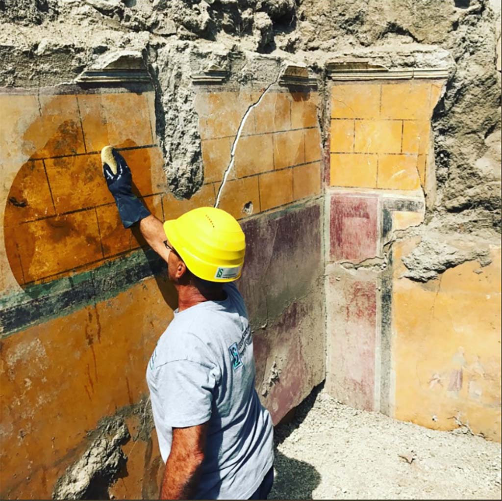 V.2.21 Pompeii. May 2018. Room A9 (as shown on PAP plan), north-west corner. On the north wall is a painting of figures with a cupid.
It is most likely a cubiculum (bedroom), due to the presence on one side of the recess intended to house the headboard of the bed.
Si trattava molto probabilmente di un cubiculum (stanza da letto), per la presenza su un lato dell’incasso destinato a ospitare la testata del letto.
See http://pompeiisites.org/wp-content/uploads/Cartella-Stampa-Regio-V-8-gugno.docx
Photograph Massimo Osanna © Parco Archeologico di Pompei.