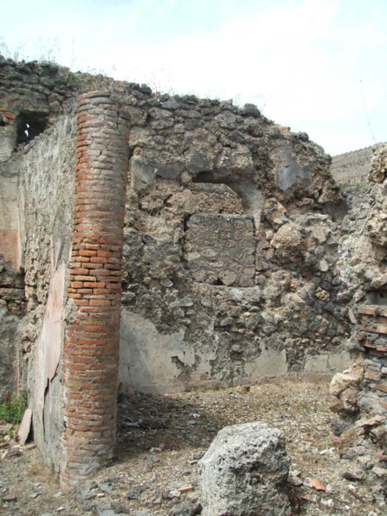 V.2.d Pompeii. May 2005. Looking towards oecus “f” on north side of vaulted passageway.
On the left is the east side of the ala “c”.
According to PPM, in ancient times the atrium would have had a roof supported by brick columns which can be seen, above, in the wall between the ala and oecus.
According to Boyce, there were two lararia in the house.
One on the east wall of the left ala of the atrium, within a panel (1.03m high, and 1.35m wide) was painted a single yellow serpent.
The serpent was moving left amidst plants towards an altar furnished with two eggs and a pine cone.
Above there may have originally been figures, but the plaster has now fallen.
See Boyce G. K., 1937. Corpus of the Lararia of Pompeii. Rome: MAAR 14. (p.36, nos.101 and 102)
See Bullettino dell’Instituto di Corrispondenza Archeologica (DAIR), 1885, p.254.