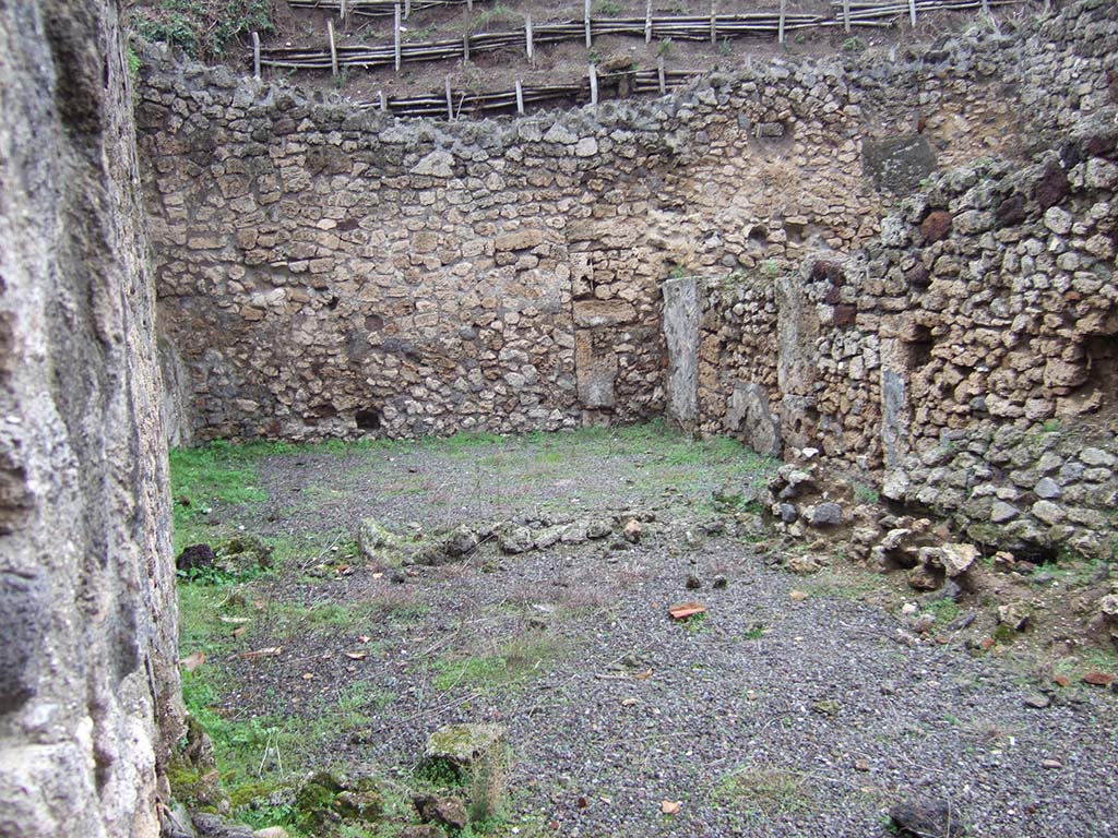 V.2.f, Pompeii. December 2005. Looking north from atrium, across site of two rooms, on left, and a corridor, on right.
According to NdS, on the north side of the atrium was a room, perhaps the triclinium, flanked by a narrow corridor.
The corridor led to another room on the north side of the triclinium, which was linked to it by a doorway.
Both the rooms were lit by windows overlooking the vicolo.