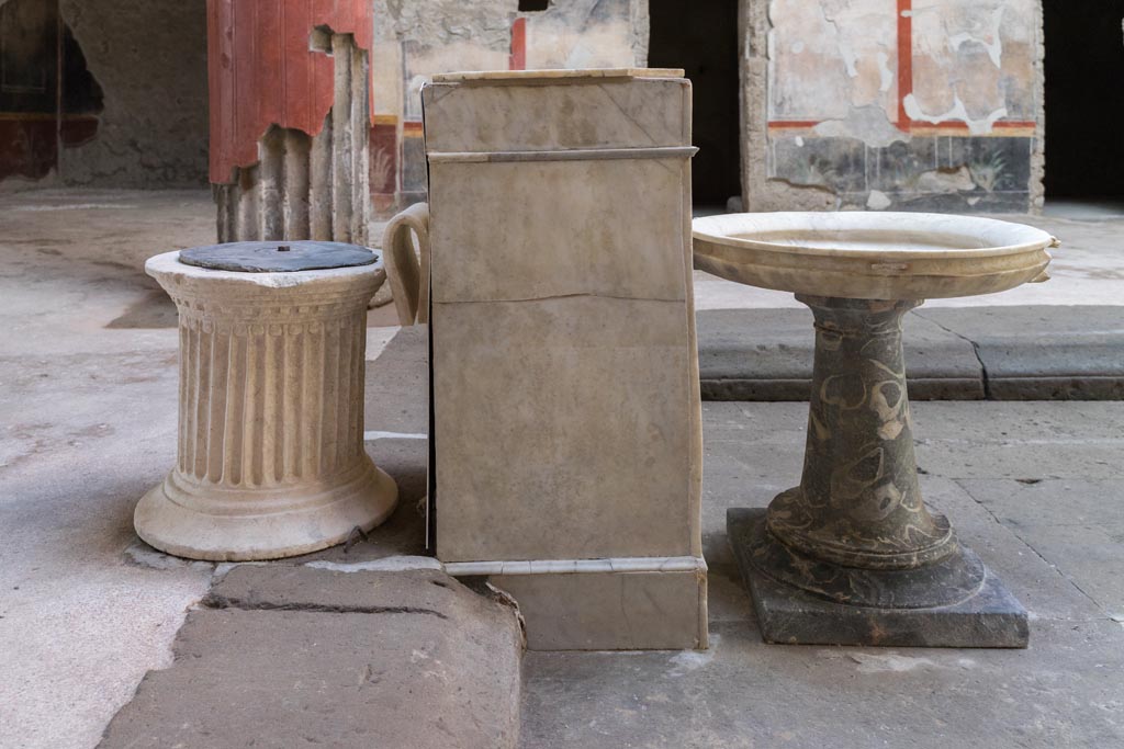 V.2.i Pompeii. March 2023. Room 1, atrium, south end of impluvium. 
Looking west towards travertine puteal, rectangular marble base and stone basin on a stand. Photo courtesy of Johannes Eber.
