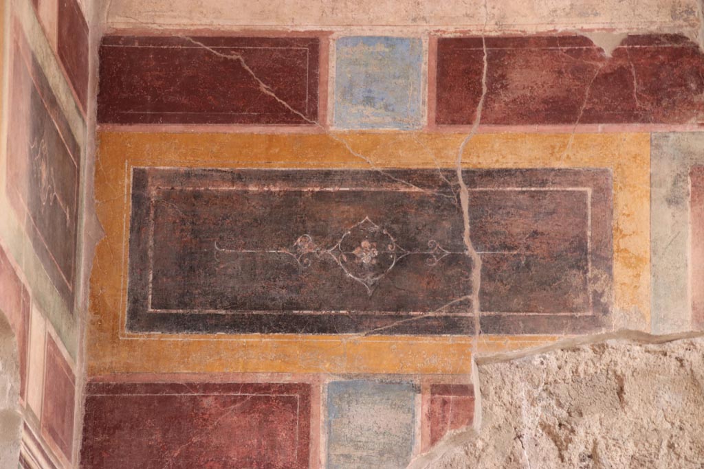 V.2.i Pompeii. October 2023.
Room 1, upper east wall at north end above doorway to room 3, detail of painted decoration. Photo courtesy of Klaus Heese.
