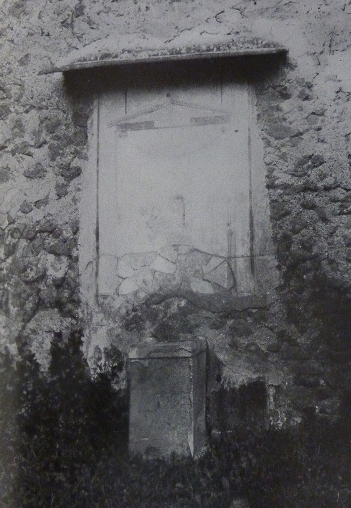 V.2 Pompeii. Casa di Orione. Old undated photograph. Garden 11c. North wall. Lararium.
The Notizie degli Scavi records a panel of white stucco.
On this is painted an aedicula, which Boyce says is painted in blue, yellow, dark red and green.
Within the aedicula is a painting of Giove (Jupiter) seated on a throne.
Underneath is a masonry altar covered with white plaster.
See Notizie degli Scavi di Antichità, 1894, p. 439.
See Boyce G. K., 1937. Corpus of the Lararia of Pompeii. Rome: MAAR 14. (96, p.35, Pl 39,3).