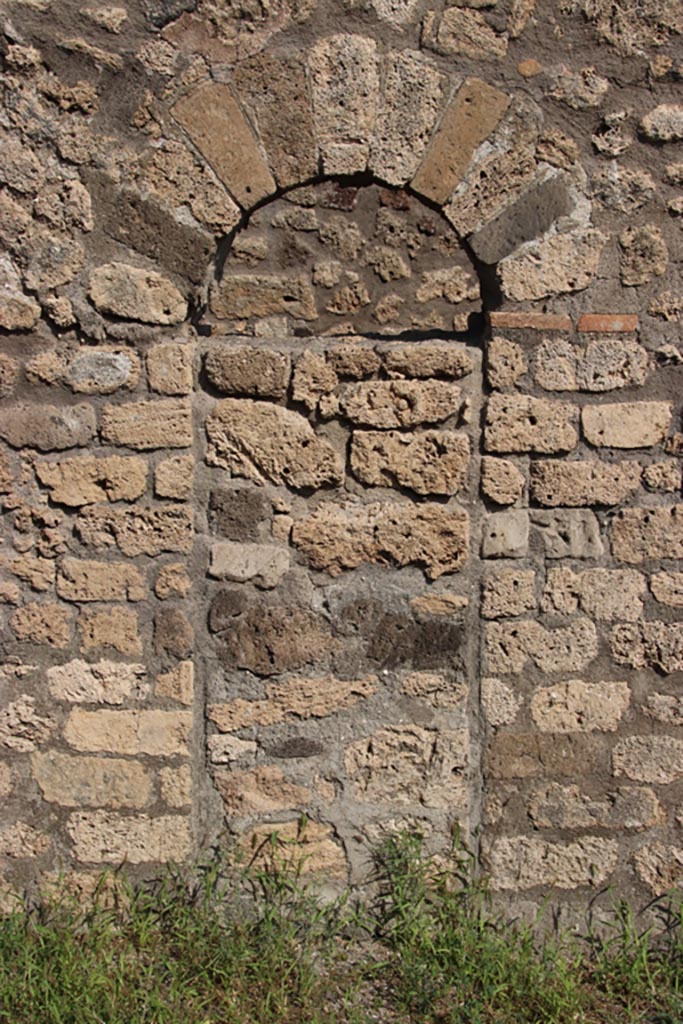 V.3.3 Pompeii. October 2023.
East wall of shop-room with blocked arched doorway to fauces of V.3.4. Photo courtesy of Klaus Heese.