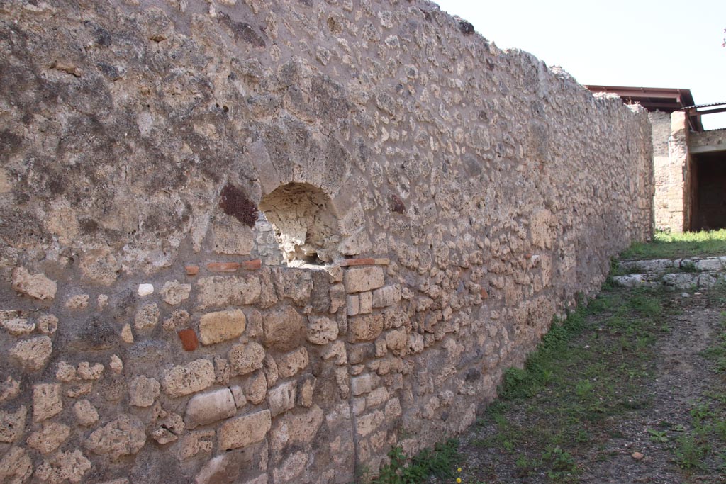 V.3.4 Pompeii. October 2023.
Looking north along west wall of entrance corridor, with blocked doorway to V.3.3. Photo courtesy of Klaus Heese.