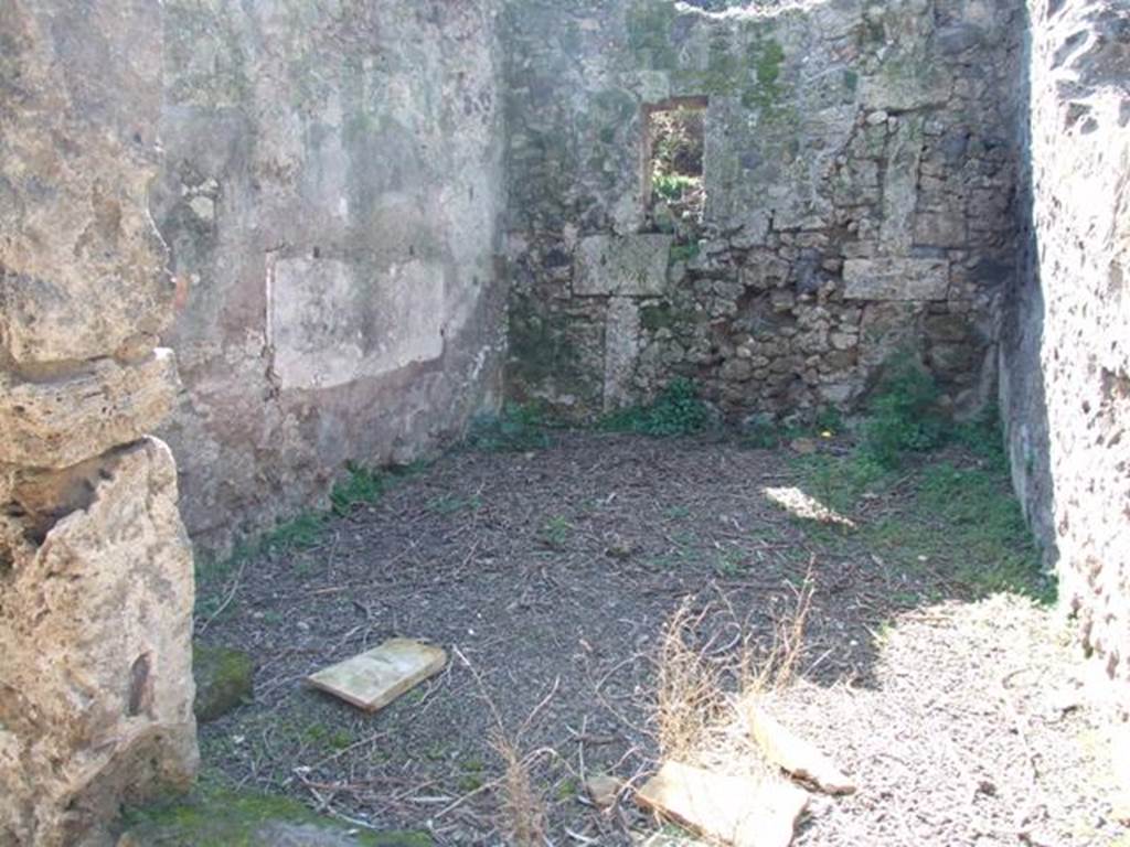 V.3.4 Pompeii. March 2009. Room on west side of portico, Looking west. According to Sogliano, this room had walls lined with rough plaster with a brick plinth. A painting of two pairs of gladiators crudely executed was found on the south wall above the remains of white plaster, at the brick plinth height. The one on the left consisted of a gladiator chasing his opponent. Also found in this room were piles of building materials, which demonstrated that the house was undergoing repairs at the time of the disaster.See Notizie degli Scavi di Antichità, 1905, (p.205)