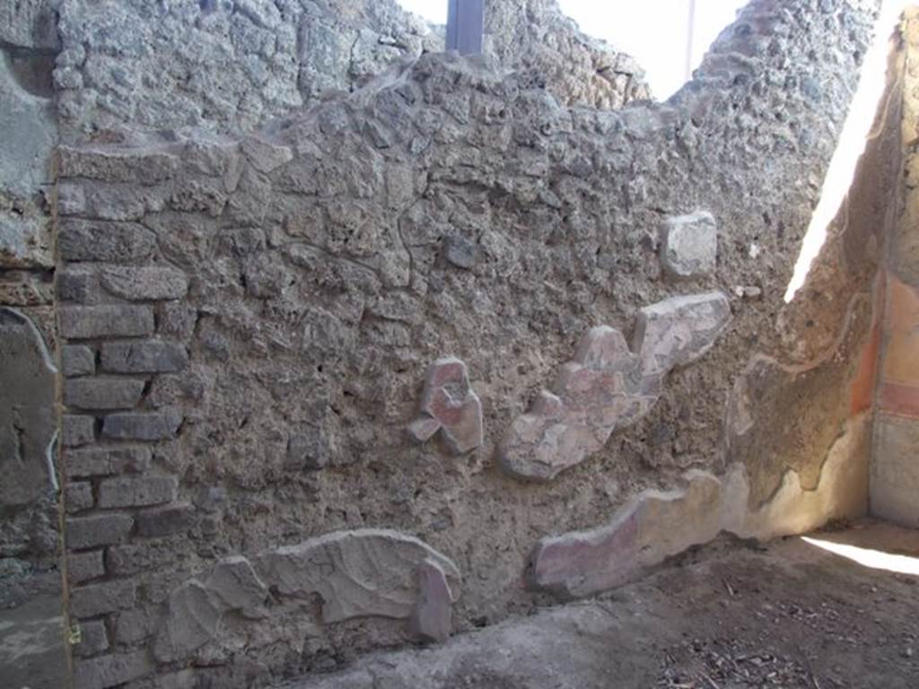 V.3.6 Pompeii. March 2009. Triclinium, east wall.
According to NdS,
“The facing east wall (from the west wall) had suffered most of all.
Only the lower part remained of the central painting, which consisted of the legs of a figure clothed in a violet robe, sitting on a noble marble rostrum whose feet were formed to look like flying griffins. On the ground, leaning against the rostrum, was a lyre with ten chords. Behind the seated figure was a standing female figure in a white robe, but only the legs remained.”
See Notizie degli Scavi, 1902, p.566.