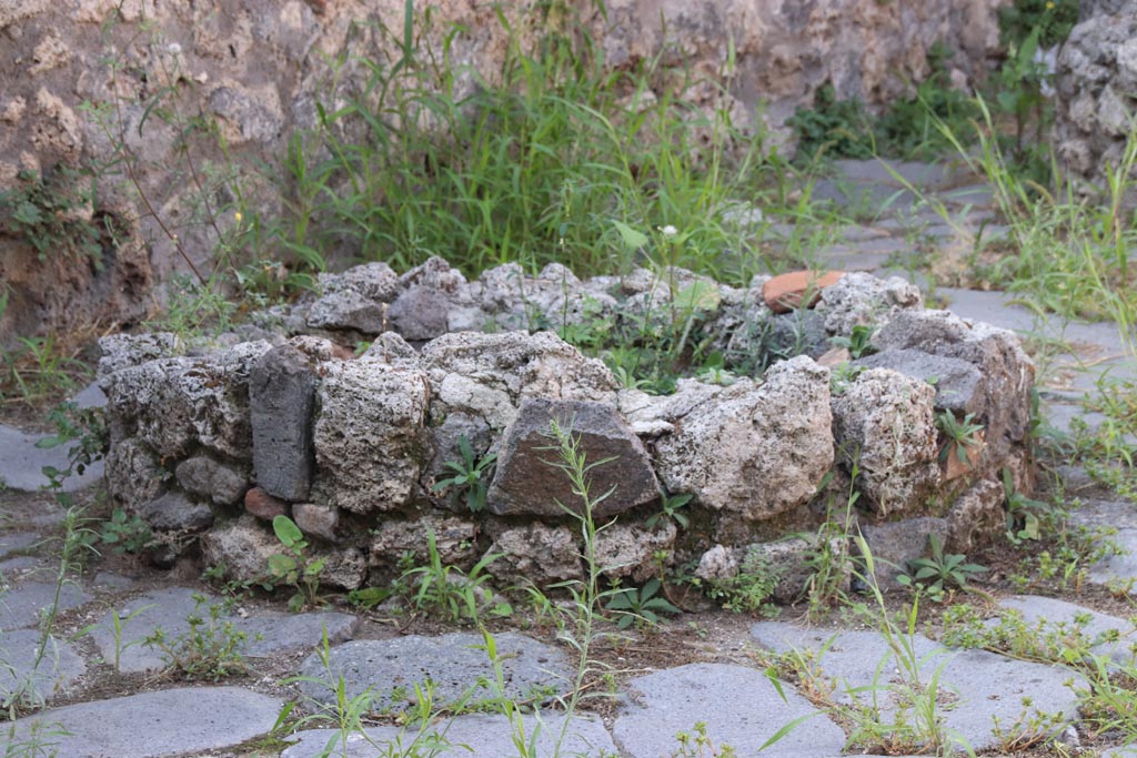 V.3.8 Pompeii. October 2023. Remains of base of mill near west wall. Photo courtesy of Klaus Heese.