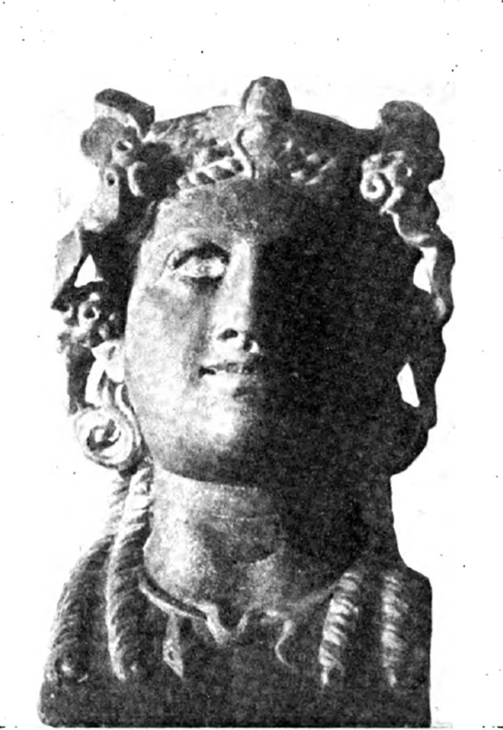 V.3.10 Pompeii. 14th September 1901. Bust of bacchante found in north-east corner of small garden.
According to Sogliano, a monopodium was found, made of two pillars, the one behind the other, and surmounted by a small little shelf of Bardiglio marble, on which was set a pretty head of a Bacchante.
It was of antique yellow marble, crowned with ivy with berries, adorned with necklace, in which wraps a snake.
Long curls fall over the shoulders, with eyes of glass paste (now non-existent) outlined in black.
Smiling with a slightly open mouth, which shows the top row of the teeth.
It is a good Roman work.
Of the two pillars, the front is of African marble; the back, broken into three pieces, is of coral rubble.
See Notizie degli Scavi di Antichità, 1901, p. 403, fig.3.