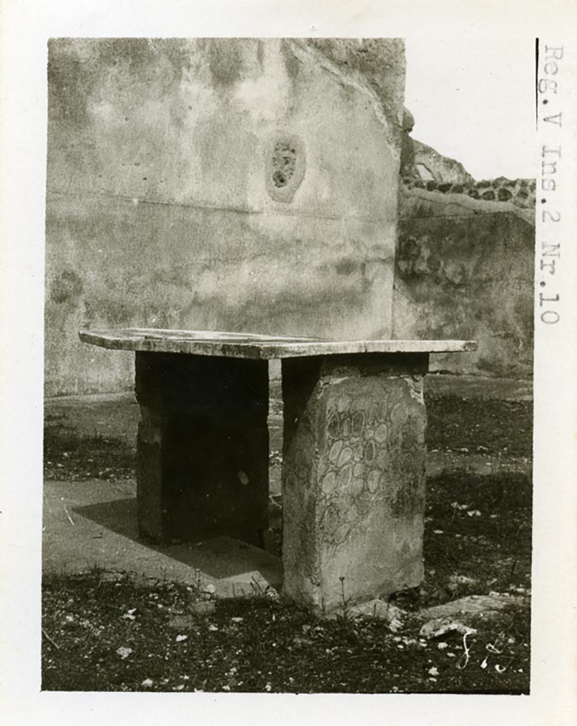 V.3.10 Pompeii, but shown as V.2.10 on photo. Pre-1937-39. Looking across table on west side of impluvium, towards north-east corner of atrium.
Photo courtesy of American Academy in Rome, Photographic Archive. Warsher collection no. 879
According to PPM,
The atrium flooring was decorated with white tesserae, of which traces were visible on the base of the impluvium, covered with cocciopesto.
The supports of the masonry table were painted in fake marble, the table was situated on the west side of the impluvium.
See Carratelli, G. P., 1990-2003. Pompei: Pitture e Mosaici: Vol. III. Roma: Istituto della enciclopedia italiana, (p. 931 pl.2.)