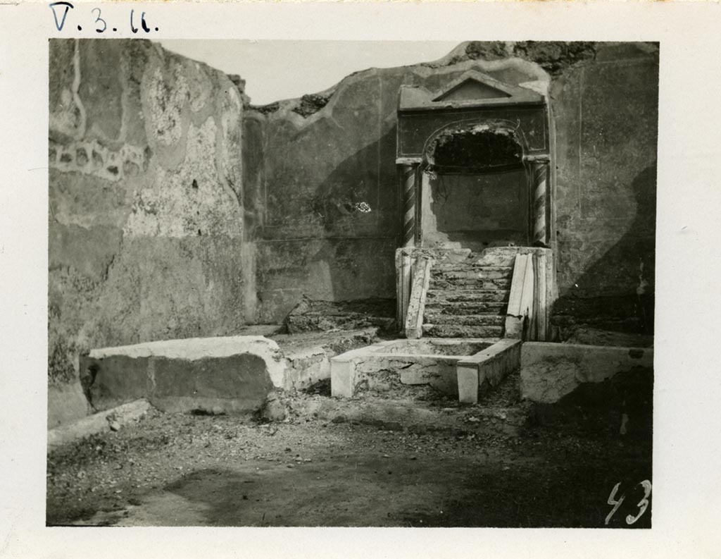 V.3.11 Pompeii. pre-1937-1939. Looking towards south wall of the garden with aedicula fountain niche, pool and biclinium.
Photo courtesy of American Academy in Rome, Photographic Archive. Warsher collection no. 437.
According to Jashemski –
On the south wall of the small garden (excavated in 1902), there was an aedicula-shaped fountain niche with a masonry couch on either side
(l. imus and l. summus, 3.00m). There was a crudely painted garden painting above each couch.
Water, perhaps from a statuette carried away in antiquity which stood in the aedicula, ran down the little steps into the rectangular pool below.
The front of the pool was concave, parallel to the curve of the niche; the back of the pool in front of the water-steps was shaped in the same way.
A jet rose in the centre of the pool. There was a planted area on each side of the pool.
A mask, intended for use as a fountain, was found in a room off the atrium.
Jashemski sources –
Parabeni, N.Sc, (1902), p.276, 371, 372 (the plan opposite p.369 gives the location of the pipes that carried water to the two fountains in the garden);
Thedenat, p.87.
Soprano, p.306, no.27.
Neuerburg, p.122-23, no.24.
Dohl, p.13.
Dwyer, "Oscilla”, p.279, no.83.
See Jashemski, W. F., 1993. The Gardens of Pompeii, Volume II: Appendices. New York: Caratzas. (p.115).