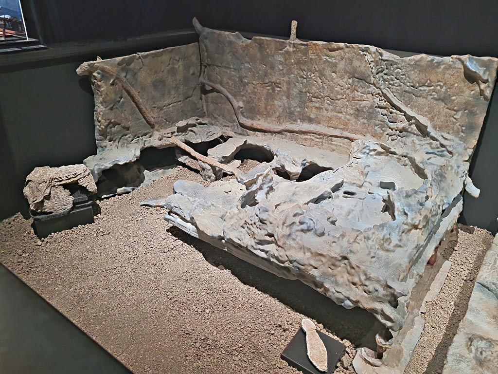 V.3.14 Pompeii. March 2024.
Room 16, casts of bed 1, letto 1 on the plan, (the bed is a copy, while those of the wicker baskets and the sole of the shoe are original.)
On display in exhibition in Palaestra entitled:- “L’altra Pompei, vite comuni all’ombra del Vesuvio”. Photo courtesy of Giuseppe Ciaramella.