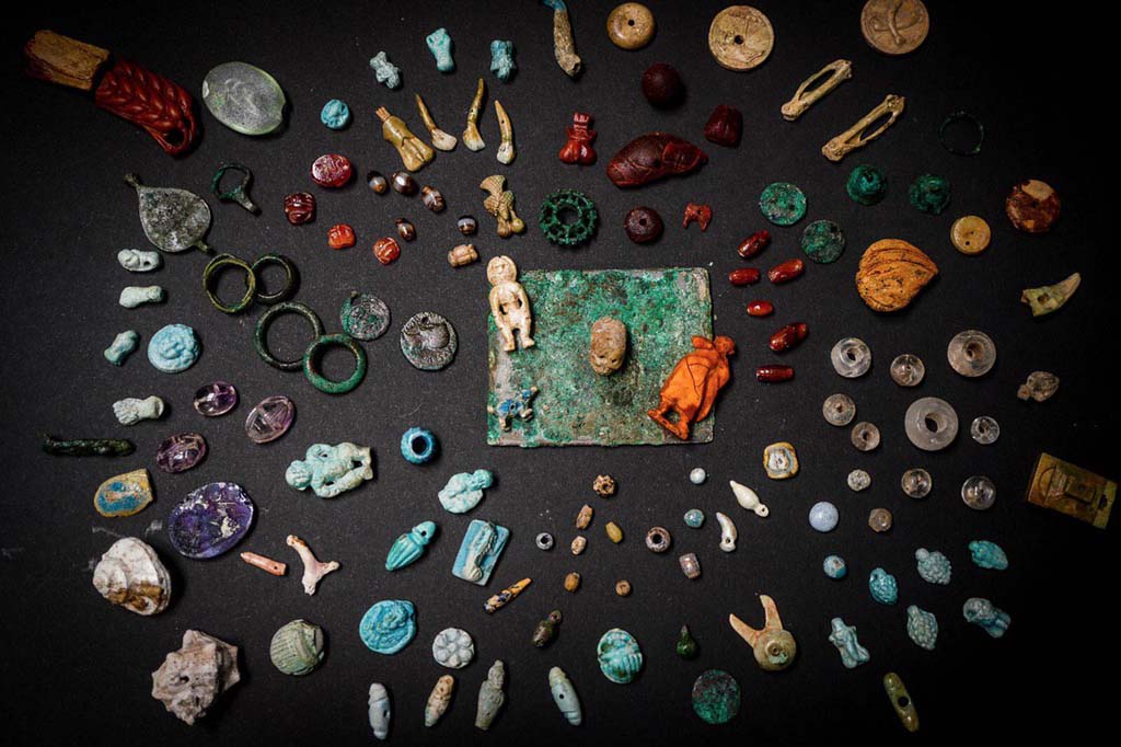 V.3 Pompeii. Casa del Giardino. August 2019. Amulets and gems for personal ornamentation or to protect against bad luck.
Amulets, gems and small objects re-emerge from the excavation of the Regio V. They were related to the female world, used for personal ornamentation or to protect from bad luck. They were found in one of the rooms of the House of the Garden.
Kept in a wooden box, they have been restored and brought to their former glory by the restorers of the Laboratory of the Archaeological Park of Pompeii. They were probably objects that the inhabitants of the house could not take away before they escaped. The wood of the box has decomposed and only the bronze hinges remain, well preserved under the volcanic material.
Among the numerous objects found, two mirrors, pieces of necklace, decorative elements made of faience, bronze, bone and amber, a glass unguentaria, phallic amulets, a human figure and various gems (including an amethyst with a female figure and a carnelian with a craftsman figure). In a glass paste is engraved the head of Dionysus, on another a dancing satyr. The high quality of the amber and glass pastes and the engraving of the figures confirm the importance of the domus owner.
"They are objects of everyday life in the female world and are extraordinary because they tell micro-stories, biographies of the inhabitants of the city who tried to escape the eruption" - says General Director Massimo Osanna - "In the same house, we discovered a room with ten victims, including women and children, and now we are trying to establish kinship relationships, thanks to DNA analysis. Perhaps the precious box belonged to one of these victims. Interesting is the iconography of objects and amulets, which invoke fortune, fertility and protection against bad luck. And the numerous pendants in the shape of small phallus, or the ear, the closed fist, the skull, the figure of Harpocrates, the scarabs. Symbols and iconographies that are now being studied to understand their meaning and function"
See PAP: The-luck-and-the-protection-against-the-bad-fate-in-the-jewelery-of-regio-v
Amuleti e gemme per ornamenti personali o per proteggere contro la sfortuna.
Amuleti, gemme ed elementi decorativi in faience, bronzo, osso e ambra riemergono dallo scavo della Regio V. Erano monili e piccoli oggetti legati al mondo femminile, utilizzati per ornamento personale o per proteggersi dalla cattiva sorte, ritrovati in uno degli ambienti della casa del Giardino.
Custoditi in una cassa in legno, e da poco restaurati e riportati al loro splendore dalle restauratrici del Laboratorio di Restauro del Parco Archeologico di Pompei, si trattava di una parte dei preziosi di famiglia, che forse gli abitanti della casa non riuscirono a portare via prima di tentare la fuga. La traccia della cassa in legno che conteneva i reperti, le cui cerniere bronzee si sono ben conservate all’interno del materiale vulcanico, a differenza della parte lignea decompostasi, è stata individuata accanto all’impronta di un’altra cassa o mobile nell’angolo di uno degli ambienti di servizio, probabilmente usato come deposito.
Sul fondo dell’impronta sono stati rinvenuti i numerosi oggetti preziosi, tra cui due specchi, diversi vaghi di collana, elementi decorativi in faience, bronzo, osso e ambra, un unguentario vitreo, amuleti fallici, due frammenti di una spiga di circa 8 cm e una figura umana, entrambi in ambra, probabilmente dal valore apotropaico, e varie gemme (tra le quali una ametista con figura femminile e una corniola con figura di artigiano). Diversi pezzi si contraddistinguono per la qualità pregiata dei materiali, oltre che per la fattura. Tra le paste vitree, straordinarie sono quelle con incise, su una la testa di Dioniso, sull’altra un satiro danzante.
Alcuni oggetti preziosi sono stati rinvenuti anche in una altra stanza della casa, presso l’atrio, dove sono stati documentati i resti scheletrici di donne e bambini, sconvolti da scavi clandestini di età moderna (XVII – XVIII secolo), probabilmente finalizzati proprio al recupero dei preziosi che le vittime portavano con sé. Solo un anello in ferro, ancora al dito della vittima, e un amuleto di faience sono casualmente sfuggiti a questo saccheggio.
Considerate le straordinarie condizioni di conservazione e la particolare qualità dei manufatti è stato possibile donar loro una nuova vita mediante un intervento di semplice pulitura e consolidamento con materiali reversibili.
“Si tratta di oggetti della vita quotidiana del mondo femminile e sono straordinari perché raccontano microstorie, biografie degli abitanti della città che tentarono di sfuggire all’eruzione. – dichiara il Direttore Generale Massimo Osanna - Nella stessa casa, abbiamo scoperto una stanza con dieci vittime, tra cui donne e bambini, di cui stiamo cercando di stabilire le relazioni di parentela e ricomporre la biografia del gruppo familiare, attraverso le analisi sul DNA. E chissà che la cassetta di preziosi non appartenesse a una di queste vittime. Particolarmente interessante è l’iconografia ricorrente degli oggetti e amuleti, che invocano la fortuna, la fertilità e la protezione contro la mala sorte. E dunque i numerosi pendenti a forma di piccoli falli, o la spiga, il pugno chiuso, il teschio, la figura di Arpocrate, gli scarabei. Simboli e iconografie che sono ora in corso di studio per comprenderne significato e funzione”
See PAP: La-fortuna-e-la-protezione-contro-la-malasorte-nei-monili-della-regio-v
Foto: Cesare Abbate/ANSA courtesy Parco Archeologico di Pompei.