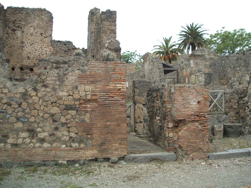 V.4.1 Pompeii. May 2005. Entrance on Via di Nola.
This doorway led to a bakery linked with a dwelling, of which the front half had already been excavated up until 1890.
Thus, from the material used, mainly predominated by limestone (Sarno stone), this house dated back to a rather ancient time, and only in later times would have been used as a bakery, as seen by the remains of decoration of the second style in the upper floor,
The doorway, once fitted with a door, led into the long and narrow entrance corridor/fauces “A”, with brick floor, in which to the right were the doorways leading into the shop at V.4.2 and with the stable “B” lit up by three windows, two overlooking into the shop and the third into the corridor; and to the left opened the entrance to a second stable “C”, linked with a third “D”. Certainly, we will not be surprised by the presence of these three stables, if one thinks of the use of animals of burden, which a bakery would have needed.