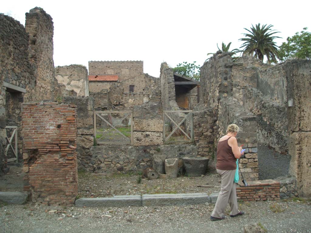 V.4.2 Pompeii. May 2005. Entrance on Via di Nola, looking north.
According to Boyce, a terracotta statuette of Minerva was found in this shop.
She was wearing a helmet, shield and aegis and holding a patera in her right hand.
The figure showed traces of its original colouring.
See Notizie degli Scavi di Antichità, 1889, 133,
See Bullettino dell’Instituto di Corrispondenza Archeologica (DAIR), xvi, 1901, 312.
See Boyce G. K., 1937. Corpus of the Lararia of Pompeii. Rome: MAAR 14. (p.108, no.3).