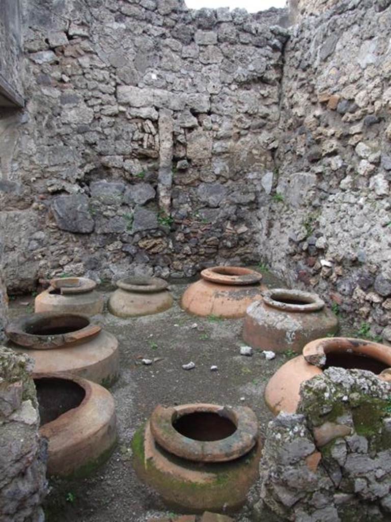 V.4.7 Pompeii. December 2007. Vinarium with eight dolia in north-west corner.
Looking west across vinarium, with doorway in south wall, on left, leading towards V.4.6.
According to Boyce, a small marble altar was found in this room.
It was decorated on the front face with a taenia (band), a patera (shallow dish) and an urceus (one handled jug).
The upper surface was divided into two sections by a ridge down the centre.
See Boyce G. K., 1937. Corpus of the Lararia of Pompeii. Rome: MAAR 14. (121; p. 40, note 2).