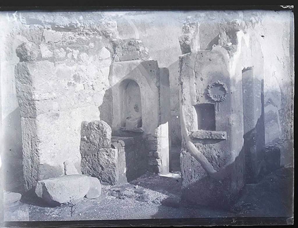 V.4.9 Pompeii. Old photo by Pierre Gusman. Kitchen on east side of atrium. The niches in the square column as described by Boyce, above, can be seen on the right of the photo.
Photo courtesy of Sandra Zanella and © Institut national d’histoire de l’art, Paris. See INHA.
Use of this photograph is subject to a CC4 (France) licence. See Creative Commons 4 (France)
