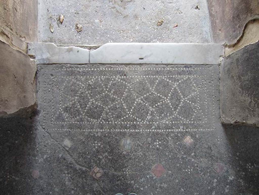 V.4.a Pompeii. March 2012.
Looking west from atrium floor towards patterned doorway threshold with marble step down to entrance corridor.
Photo courtesy of Marina Fuxa.