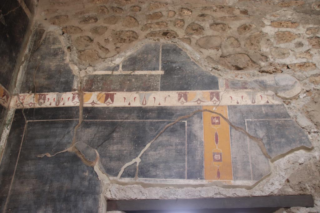 V.4.a Pompeii. October 2023.
Upper south wall of atrium in south-east corner, detail of painted decoration above doorway to room ‘g’. Photo courtesy of Klaus Heese.