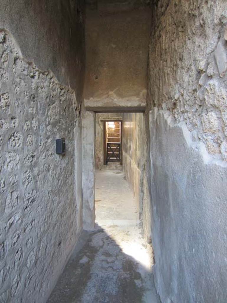 V.4.a Pompeii. March 2012. Looking west along corridor from garden, leading towards the north side of the atrium. The steps to upper floor in north-west corner of atrium can be seen. Photo courtesy of Marina Fuxa.