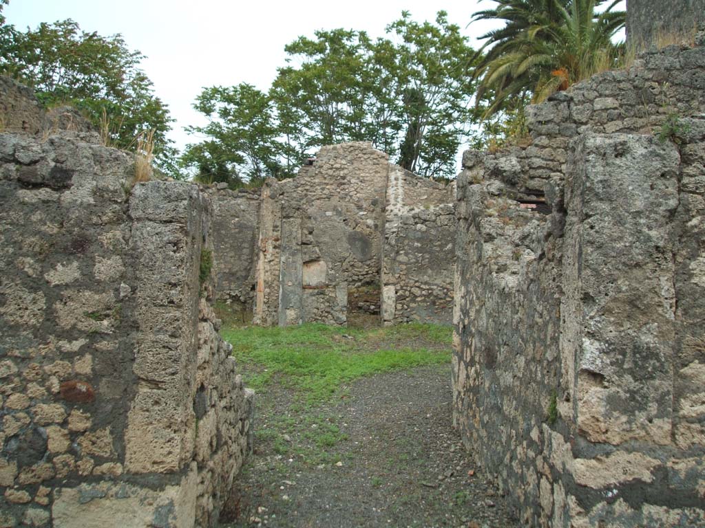 V.4.b Pompeii. May 2005. Entrance doorway, looking east.
According to Garcia y Garcia, this small house was badly hit by a falling bomb, during the night of 16th September 1943.
This led to the destruction of the entrance corridor, the atrium and some rooms to the north.
He wrote, it remained forgotten without any restoration.
During the 1982 control for the RICA plans, he saw the debris of the bombed rooms still heaped up, in situ.
See Garcia y Garcia, L., 2006. Danni di guerra a Pompei. Rome: L’Erma di Bretschneider. (p.62)