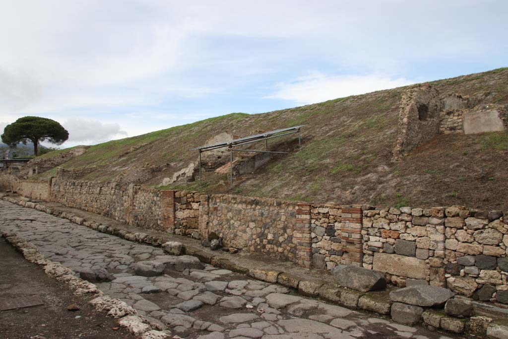 Via del Vesuvio, Pompeii. October 2020. Looking north along east side of roadway, insula 6 of Reg.V.
V.6.3 would appear to be the house doorway, seen centre right, at the side of the large block on the pavement. Photo courtesy of Klaus Heese.