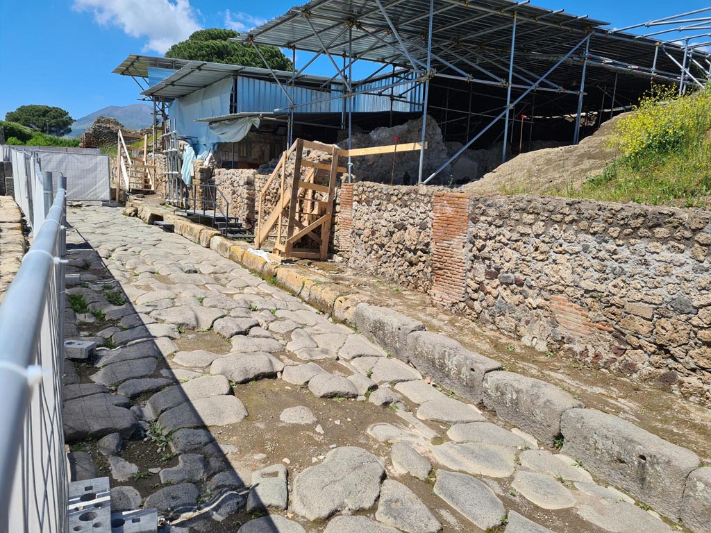 V.6.11 Pompeii. May 2024.
Looking north towards east side of Via del Vesuvio, with entrance doorway with wooden steps, in centre. Photo courtesy of Klaus Heese.