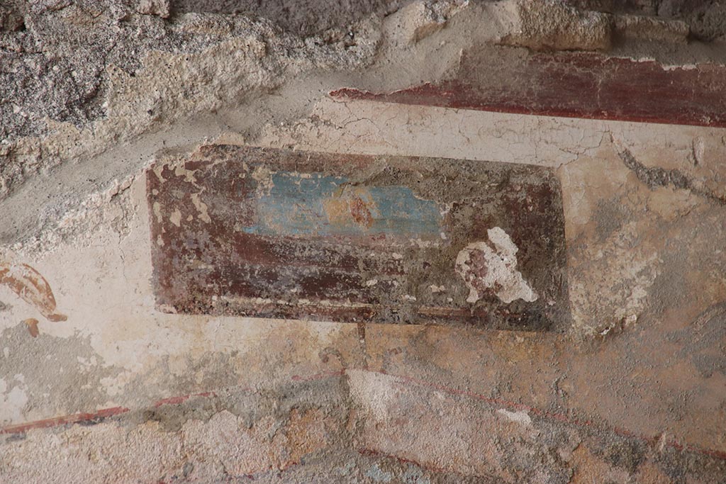 V.6.12 Pompeii. October 2024.
Detail of painted panel from upper north wall of fauces/ entrance corridor above Priapus painting. Photo courtesy of Klaus Heese.