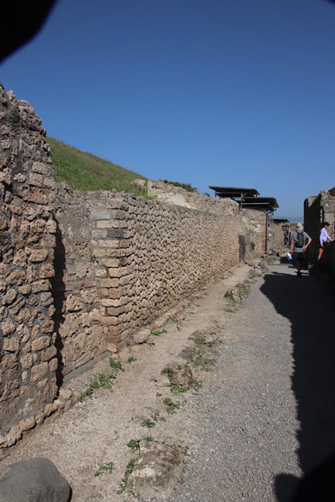 V.6.a/b/c. Pompeii. October 2023.
Looking east along north side of Via delle Nozze d'Argento. Photo courtesy of Klaus Heese.
