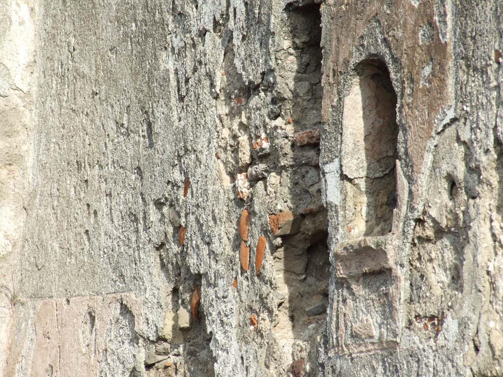 VI.1.1 Pompeii. December 2007. Arched niche on east wall of room 10 (see Mazois plan), photo taken from VI.1.4.
Originally this niche was at the end of a passage from the triclinium.
The wall around the niche was painted with red stucco. Red, rose-like flowers were painted inside the niche.
See Boyce G. K., 1937. Corpus of the Lararia of Pompeii. Rome: MAAR 14. (p.43, no.132)
See Fröhlich, T., 1991. Lararien und Fassadenbilder in den Vesuvstädten. Mainz: von Zabern. (L55, Picture 37,1)