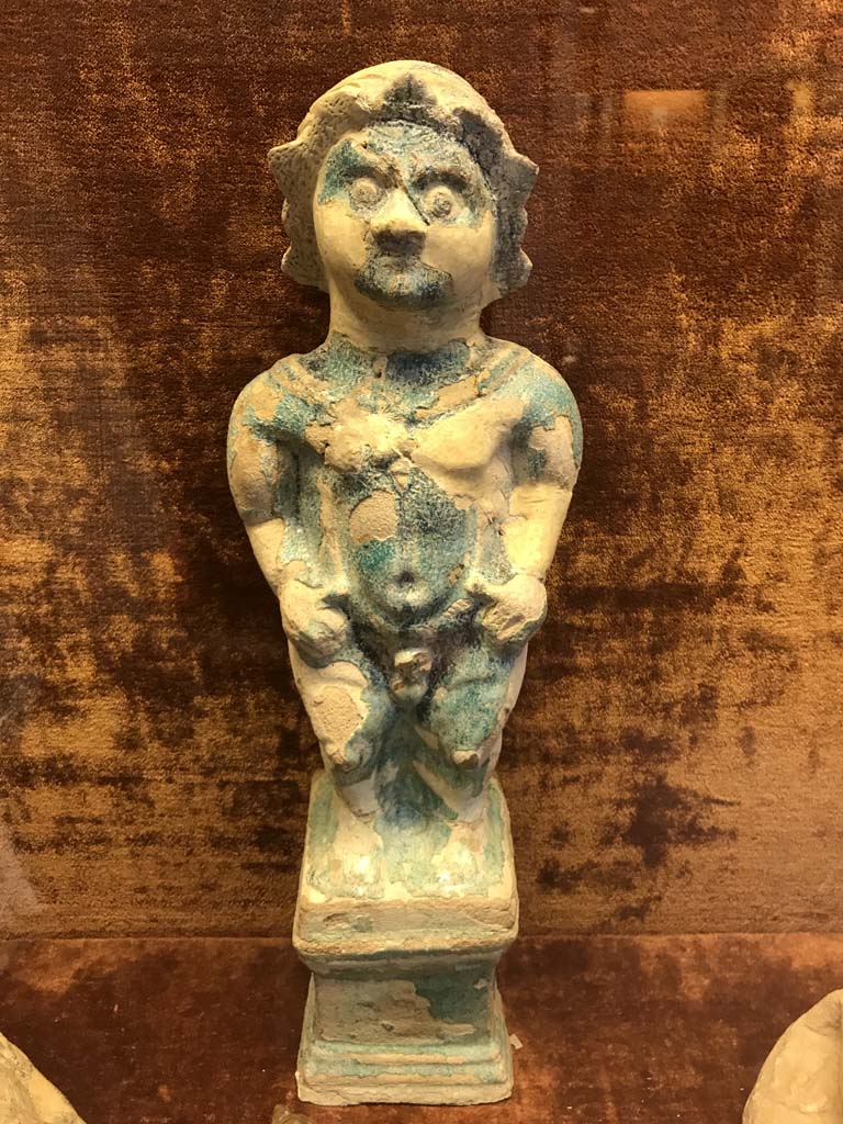 VI.1.2 Pompeii. April 2019. Statuette of Ptah-Pateco found in VI.1.2 on 6th October 1770.
Photo courtesy of Rick Bauer.
Now in Naples Archaeological Museum. Inventory number 22607.
Sala (room) 88, glass cabinet V, shelf A (bottom).
See Di Gioia, E. (2006). La ceramica invetriata in area vesuviana. “L’Erma” di Bretschneider, (p.110-111).