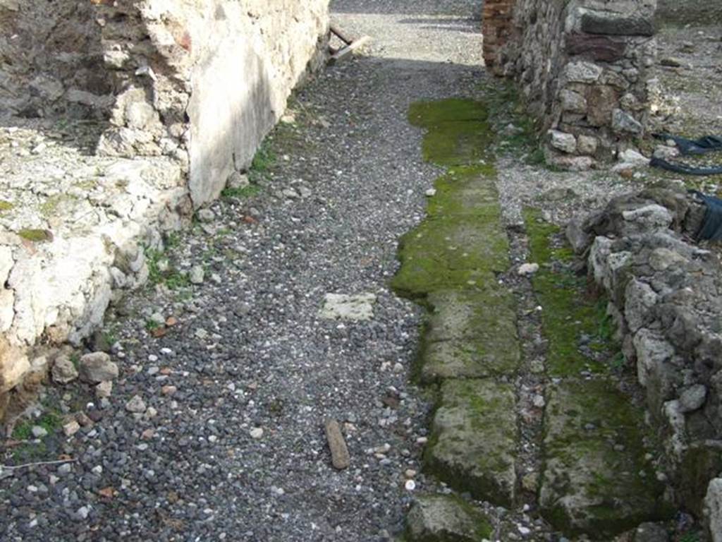 VI.1.7 Pompeii. December 2007. Floor of corridor room 40, showing channel in stone for water-pipes. These would have fed the fountain or water feature in room 41, that would have led from a junction (on the right, centre of photo). See Dobbins, J & Foss, P., 2008. The World of Pompeii. New York: Routledge. (p.399)