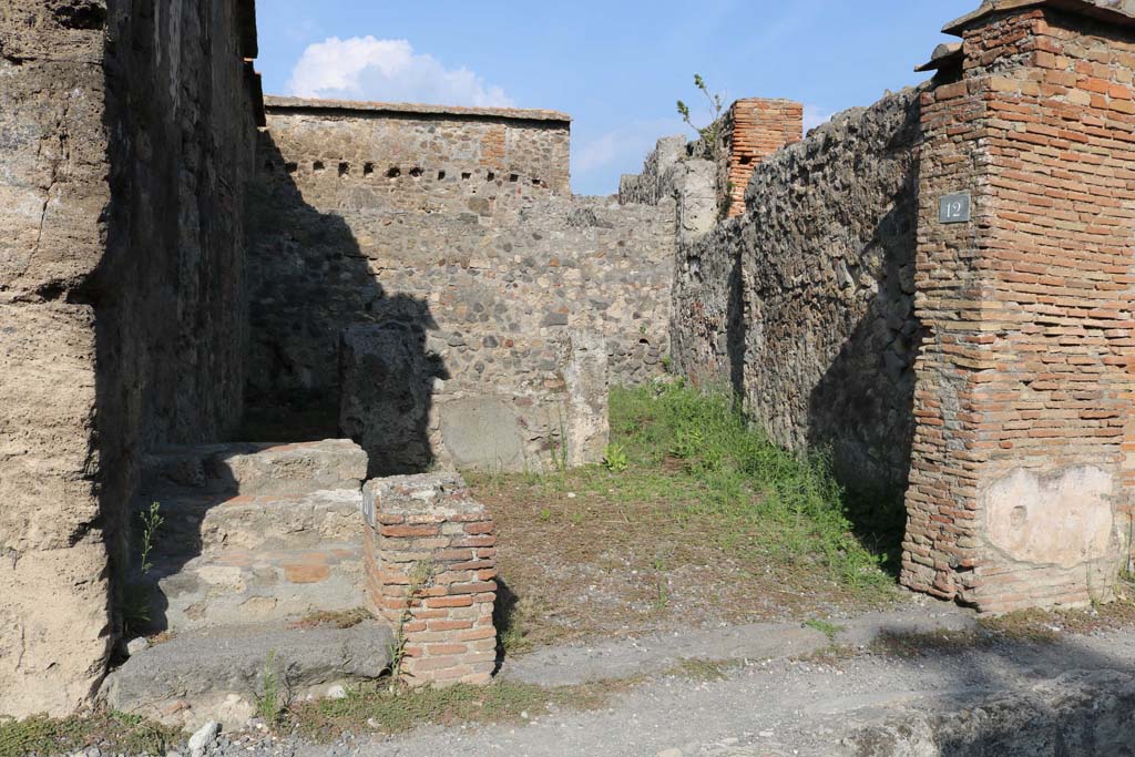 VI.1.12 Pompeii, on right. December 2018. Looking east to entrance to shop, with rear room.
On the left are the steps to an upper floor, numbered VI.1.11. Photo courtesy of Aude Durand.