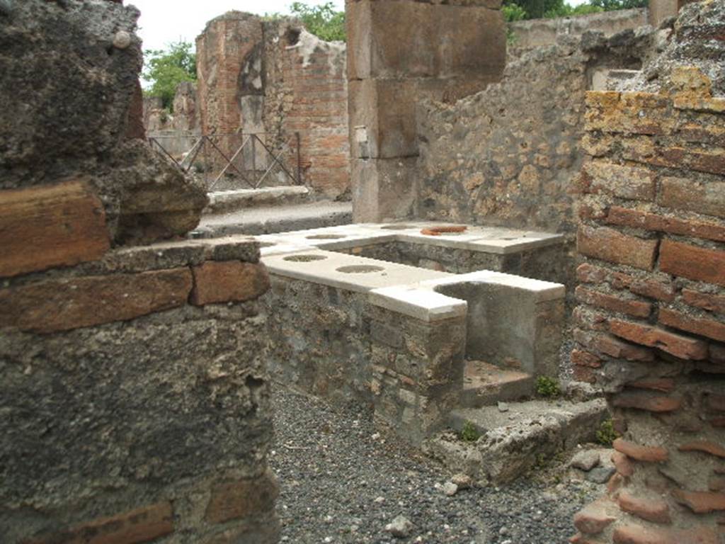 VI.2.1 Pompeii. May 2005. Looking from rear. Marble counter with six urns and a hearth.