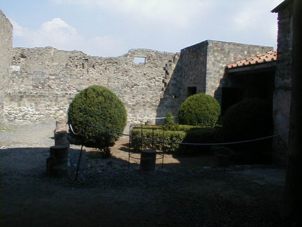 VI.2.4 Pompeii. September 2004. Looking east across portico of small garden. This was originally a three sided peristyle. It was destroyed by a huge bomb in September 1943. It was reconstructed in 1970-71 based on an 1824 plan by Mazois. It should be noted that apart from the west side, the house was entirely destroyed by the bombing during the night of 14/15th September 1943. According to Laidlaw, the roof, the south apartment, and the portico behind the main house block are almost completely modern reconstructions made in 1970-71. See Garcia y Garcia, L., 2006. Danni di guerra a Pompei. Rome: L’Erma di Bretschneider. (p. 66-74)