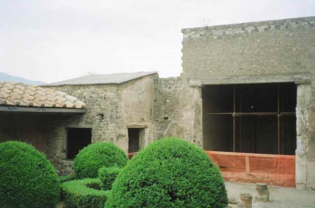 VI.2.4 Pompeii. May 2010. Looking south-west across small garden. Photo courtesy of Rick Bauer. According to Jashemski, the rooms on the south part of the house were added at a later date around a peristyle garden. There was a portico on the north and part of the east and west sides, supported by seven, eight-sided dark red columns with white capitals. There was a gutter on the east, north and west sides.
Mau reported a pool and fountain in the middle of the garden but bombing in September 1943 destroyed all evidence of these.
There was a cistern-opening near the north-west corner of the garden.
The triclinium on the west had a good view of the garden. See Jashemski, W. F., 1993. The Gardens of Pompeii, Volume II: Appendices. New York: Caratzas. (p.121)
