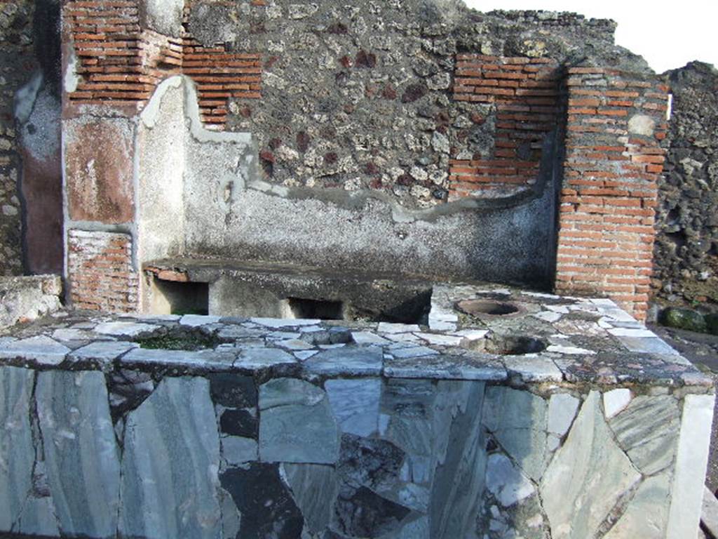 VI.3.20 Pompeii. December 2005. Looking east across counter. According to Breton:
This bar of Fortunata had a counter of masonry which held several large terracotta containers, and was covered with a marble tablet, where the footprints of cups/glasses could still be recognised.
The liquids contained in them must have contained some acid principle which had attacked the polish of the marble.
At the rear was a higher area which held the brazier for heating various beverages.”
See Breton, E., 1855. Pompeia, decrite et dessine, (p.219)