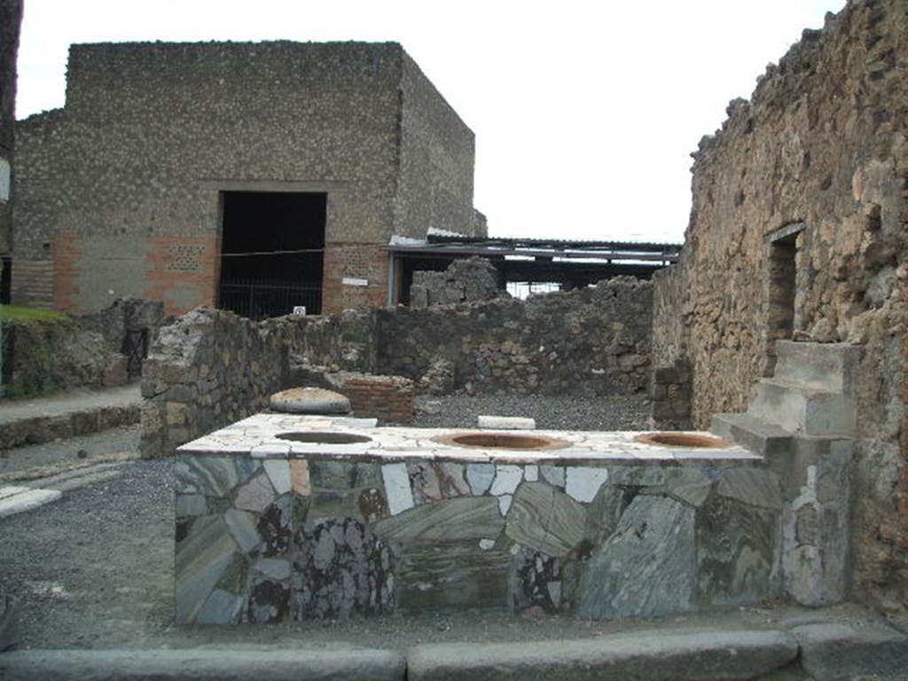 VI.4.8 Pompeii. December 2006. Sales counter, looking west to rear room.
The entrance, VI.4.9 on Via delle Terme, can be seen on the south (left) side. According to Garcia y Garcia, this area was nearly all destroyed by the bombing in 1943. The bomb provoked the total fall of the walls, internal and external onto Via Consolare, between the north wall and on its east side.
See Garcia y Garcia, L., 2006. Danni di guerra a Pompei. Rome: L’Erma di Bretschneider. (p.75)