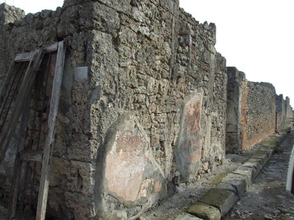 VI.5.9 Pompeii. December 2007. Wall in Vicolo di Modesto between VI.5.9 and VI.5.10, looking south. According to Fiorelli, the exterior walls of the house were plastered red.
