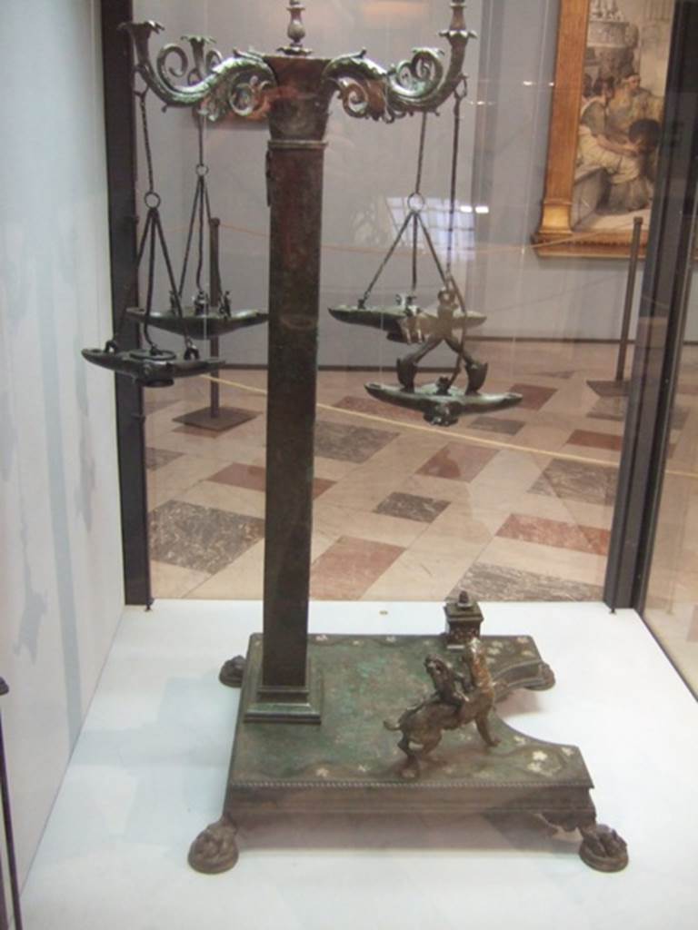 Bronze candelabrum with four volute branches for lamps. Found in VI.6.1 House of Pansa. Now in Naples Archaeological Museum.