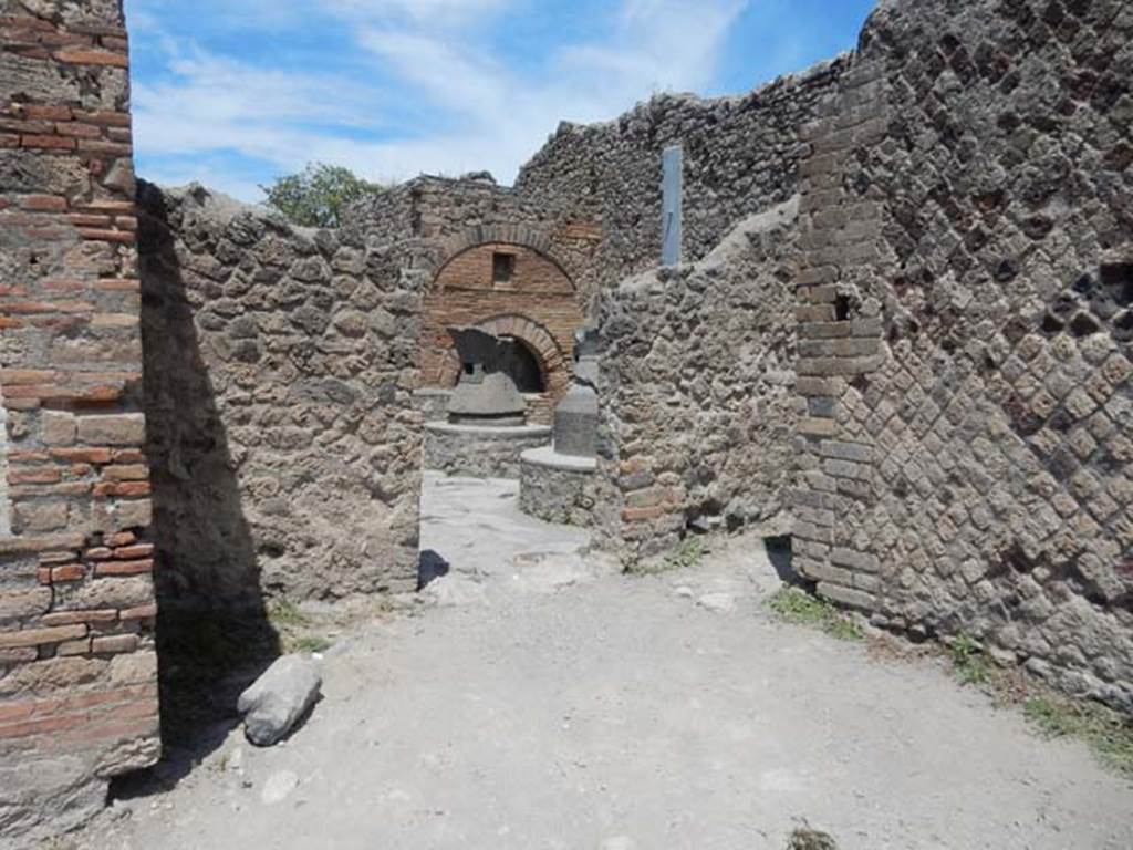 VI.6.17 Pompeii. May 2017. Looking towards north wall of entrance room with doorway to bakery. On the right is a doorway to a small rear room. This small rear room may have been a storeroom for the flour, or possibly a stable for the animals used to turn the mills. Photo courtesy of Buzz Ferebee.