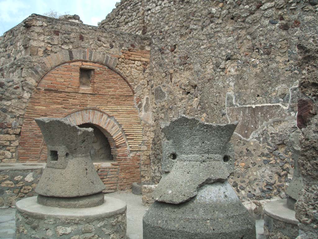 VI.6.17 Pompeii. May 2005. Looking north through doorway into bakery.
In this room were found three broken mills, a bench, a bin sunk below the floor near the east wall, and the oven.
Also found were some terracotta pots for the water.