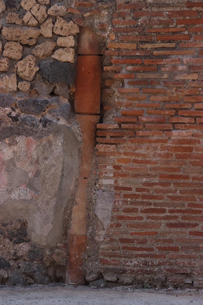 VI.7.10 Pompeii. October 2022.
Downpipe on south side of entrance doorway, between VI.7.9 and 10, in front façade.
Photo courtesy of Klaus Heese.