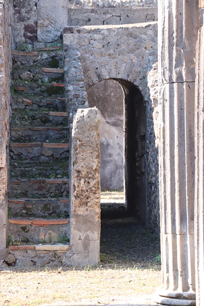 VI.7.21 Pompeii. October 2022.
Staircase to upper floor, and corridor through arch to rear and linking with peristyle of VI.7.20.
Photo courtesy of Klaus Heese.