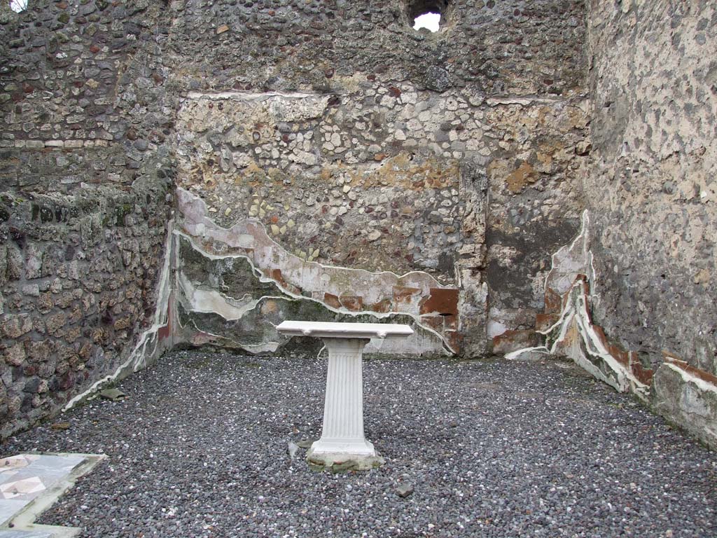VI.7.23 Pompeii. December 2006. Table in triclinium, with walls showing many levels of painted plaster.
The beautiful flooring was coloured marble opus sectile of square and triangular tiles, see sample in lower left.