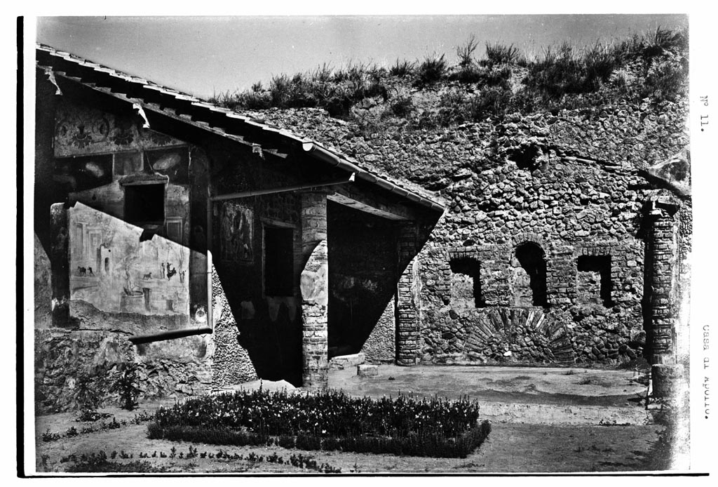 VI.7.23 Pompeii. W.1585. Looking north across garden to summer triclinium.
Photo by Tatiana Warscher. Photo © Deutsches Archäologisches Institut, Abteilung Rom, Arkiv.
According to Soprano –
Ubicazione: xystus.
Bibliog. Fiorelli, op. c., p.115; Breton, op. c., p.275; Dyer, op. c., p.391.
In fondo allo xystus appare uno spazio rettangolare con pavimento a mosaico e tettoia a doppio spiovente, sorretta da due semi-colonne addossate al muro di fondo e da quattro colonne. Di queste esistono solamente le due del lato occidentale, ricostruite per il restauro della tettoia.
Sul muro di fondo si aprono tre nicchie, la centrale absidata e le due laterali rettangolari.
Completamente privi di intonaco sono le nicchie e il muro di fondo che pero era rivestito, come le colonne, di marmo nella parte inferiore e di pasta vitrea policroma e di conchiglie nella parte superiore.
Il mosaico del pavimento e oggi completamente distrutto.
See Soprano, P. (1950). I triclini all’aperto di Pompei. (In Pompeiana, raccolta di studi per il secondo centenario degli scavi di Pompei. Napoli, Gaetano Macchiaroli, Editore, p.308, no.33.
According to Jashemski –
At the rear (north end) of the garden were four columns and two engaged columns, covered with blue-grey marble to a height of 0.20m., some with traces of mosaic and shells preserved above. Between the two engaged columns on the north wall was a round-headed niche with a rectangular niche on either side. The latter were at least partly lined with marble, and there is still some blue mosaic in the centre niche. The wall was covered with pumice. …….etc.
Most scholars believe that the columns supported a pergola, but beyond that there is little agreement. Fiorelli and Soprano believed that the pergola once shaded a garden triclinium. Breton, Fiorelli and Warscher believed that the niches held the statues of deities. Sear believed that it was a nymphaeum, but Neuerburg does not include it in his catalogue of the fountains and nymphaea of ancient Italy. No water pipes are reported, not any indications of a fountain, such as a basin below, as in the garden of the house of the Little Bull (V.1.7). The area between the columns is said to have had a mosaic pavement, but nothing of it remains today. Professor Richardson suggested to me that a mosaic pavement would not have been completely exposed to the elements, and that it may have been roofed with thatch, or possibly with canvas.
See Jashemski, W. F., 1993. The Gardens of Pompeii, Volume II: Appendices. New York: Caratzas. (p.132).