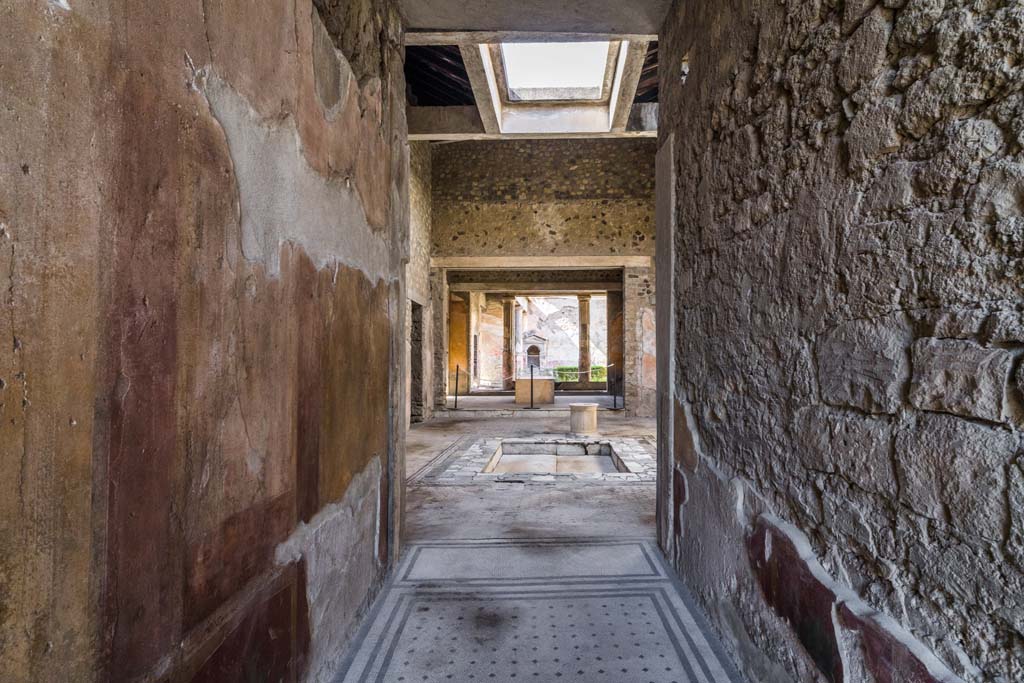 VI.8.3/5 Pompeii. April 2022.
Looking north along entrance corridor across atrium towards peristyle with lararium. Photo courtesy of Johannes Eber.