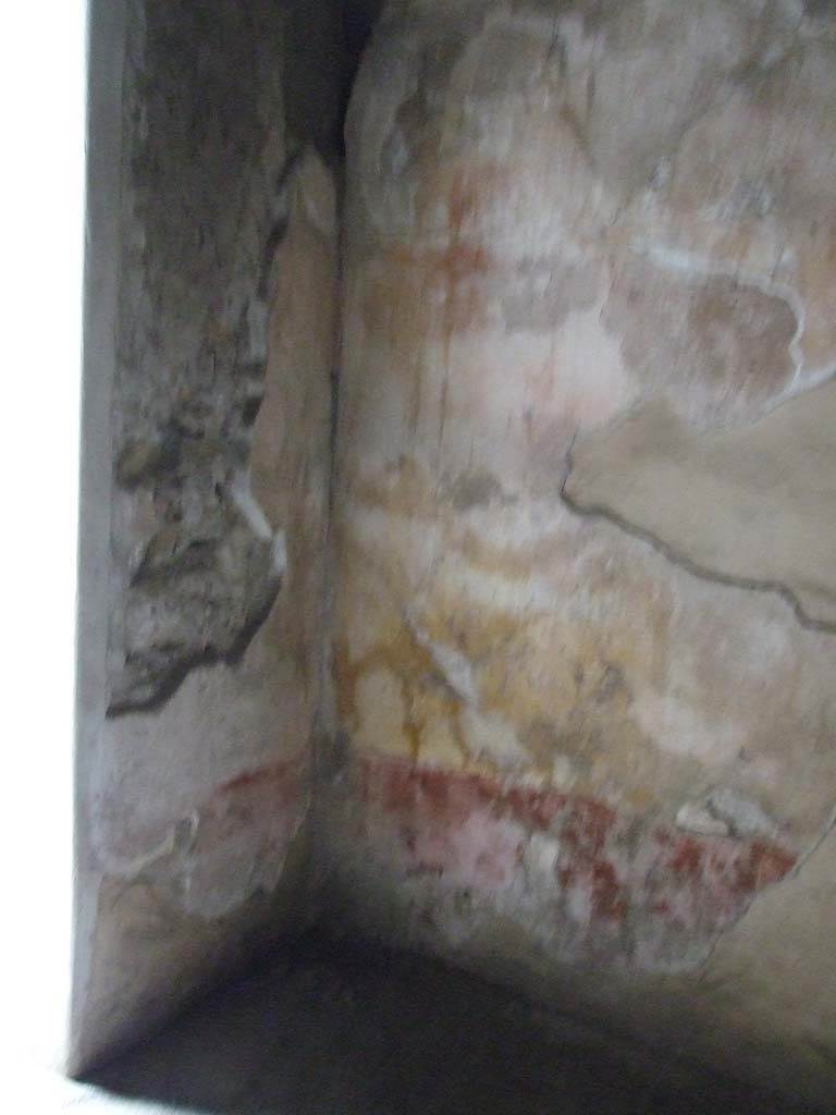 VI.8.5 Pompeii. March 2009. Room 3, west and north walls of cubiculum.
The walls would have had a red zoccolo separated by panels and compartments; the middle zone had yellow panels edged with carpet borders.
The upper zone was faded and illegible.
