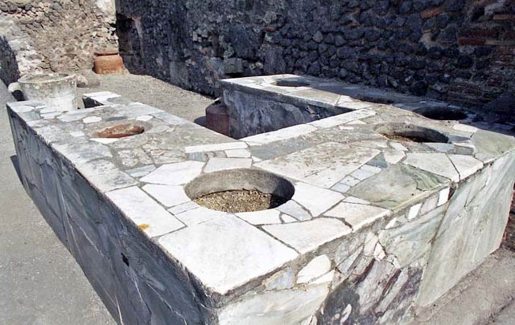 VI.8.8 Pompeii, October 2001. Marble counter in bar-room, with six urns and hearth.
Photo courtesy of Peter Woods.
