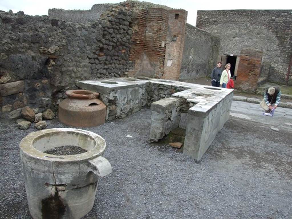 VI.8.8 Pompeii. March 2009. Rear of counter on east side, with remains of hearth and dolium.